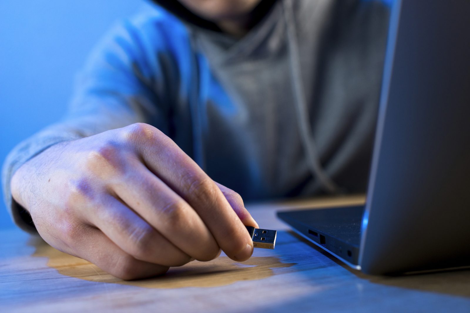Hand inserting a USB stick into a laptop, image for a security test